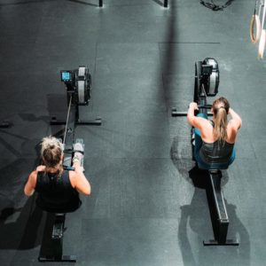 dve ženy cvičia na veslovacom trenažéri