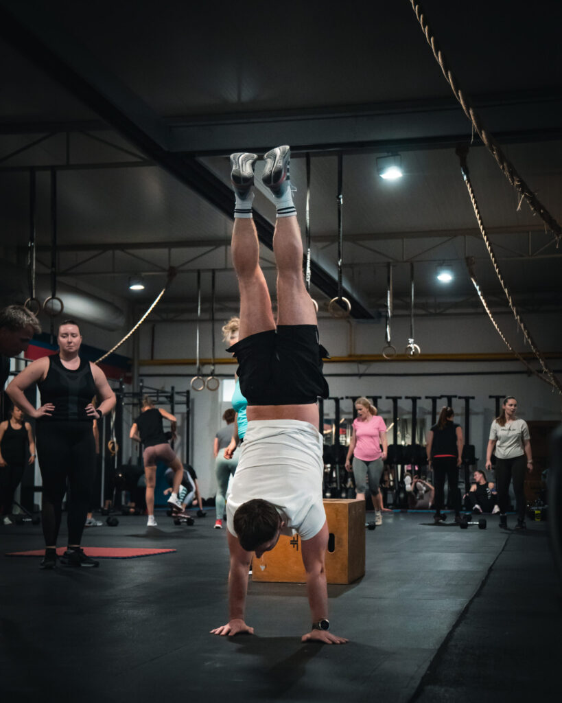 Člen CrossFit Senec robí stojku na rukách počas tréningu gymnastiky