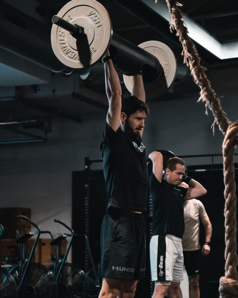 Člen CrossFit Senec tlačí strongman brvno nad hlavu